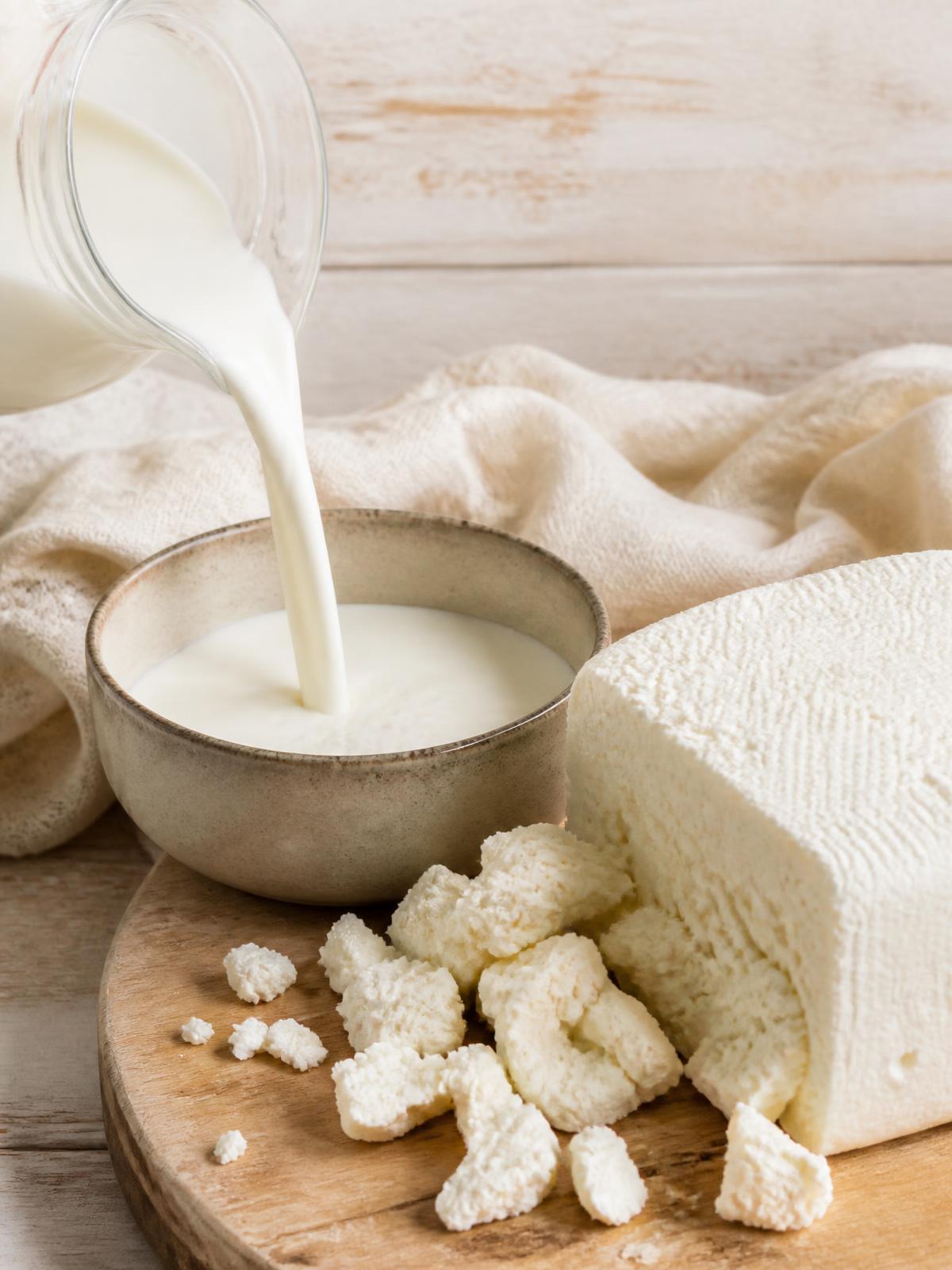 Fresh milk poured beside a block of Queso Llanero